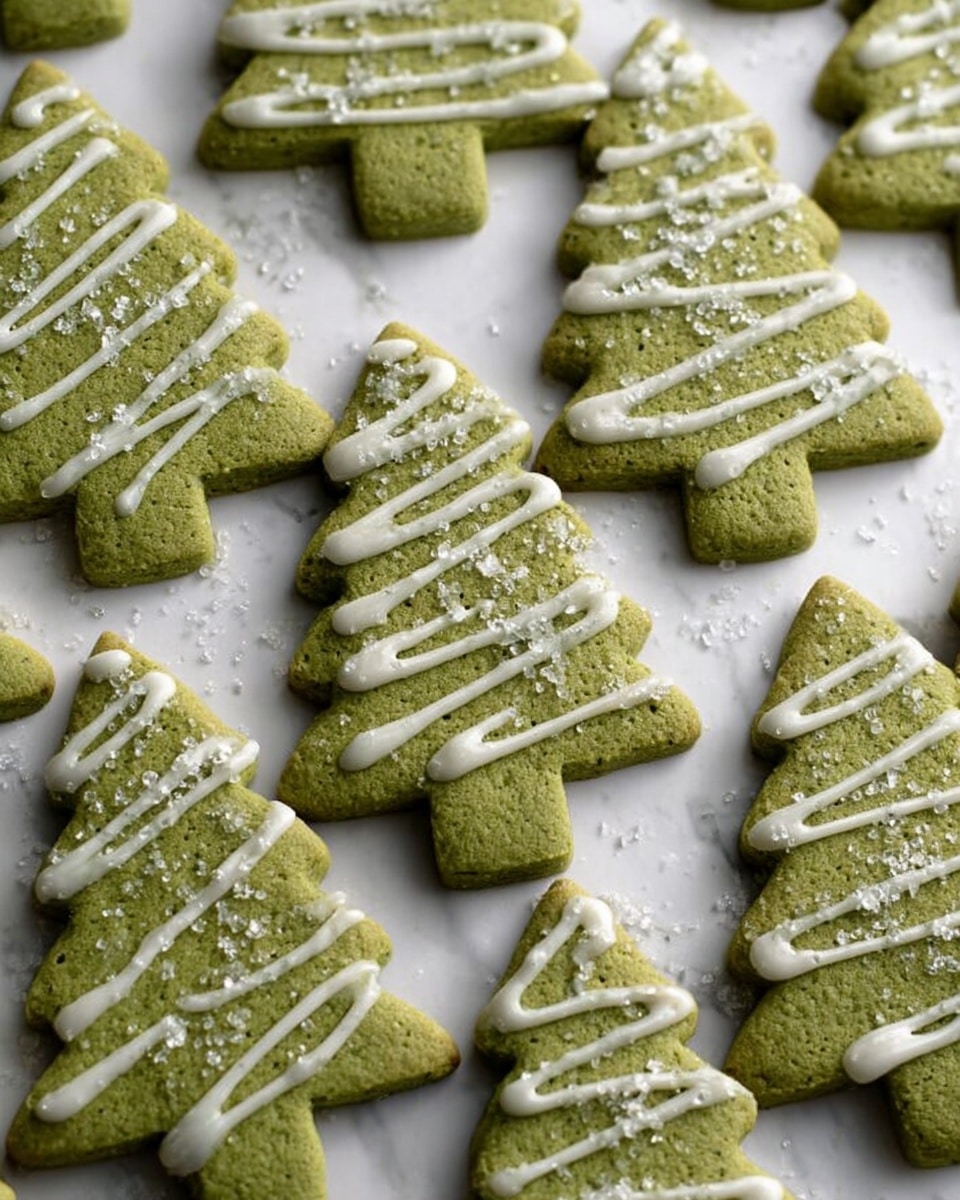 The image shows many Christmas tree-shaped cookies arranged closely on a white marbled surface. Each cookie has a rough green texture, indicating a likely matcha or green tea flavor. The trees have a zigzag drizzle of white icing on top, creating a simple decoration along the width. Small white sugar crystals are scattered evenly over the cookies, adding a bit of sparkle and texture. The cookies are flat with distinct tree edges and appear evenly baked. photo taken with an iphone --ar 4:5 --v 7