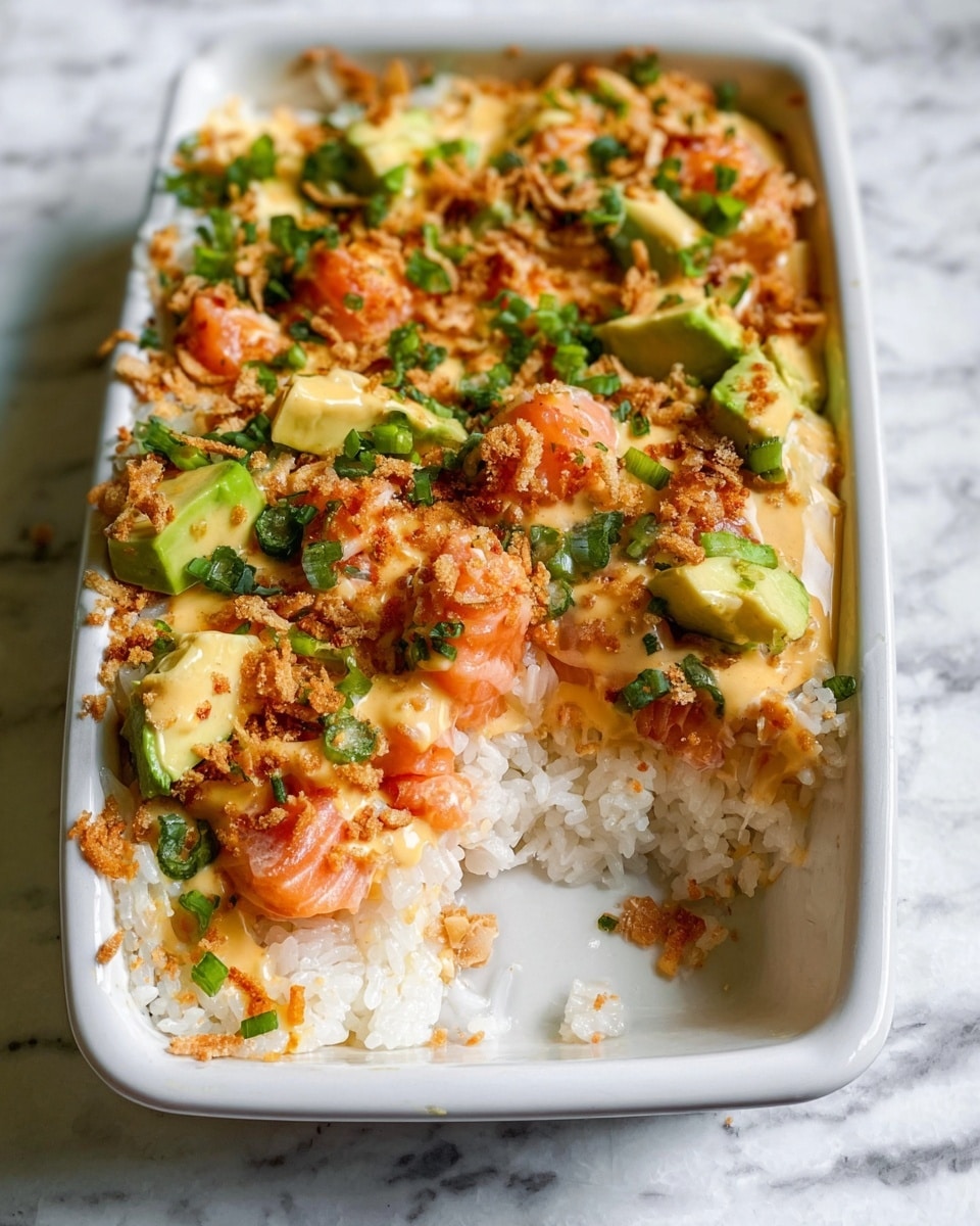 A white rectangular dish shows a layered rice dish with a missing round scoop in the front center. The bottom layer is white sticky rice, smooth and thick. On top, there are chunks of orange cooked salmon, covered in a pale orange creamy sauce. Green avocado pieces and small chopped green onions are sprinkled over the salmon. Light brown crunchy bits are scattered across the whole dish, adding texture. The dish sits on a white marbled surface. Photo taken with an iphone --ar 4:5 --v 7