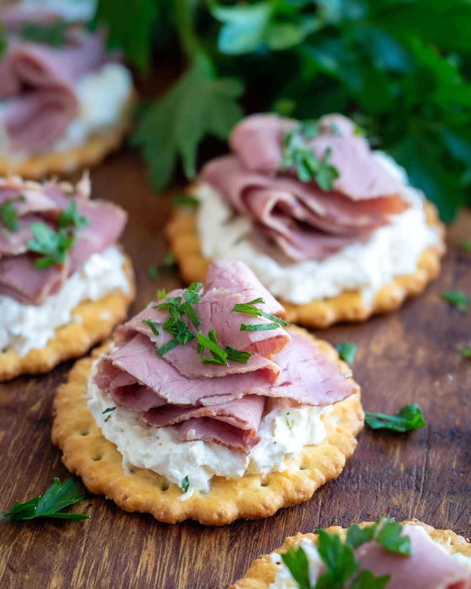 The image shows several round crackers with three distinct layers arranged on a wooden surface. The bottom layer is the golden-brown cracker, followed by a thick layer of soft, white creamy spread. On top, there are folded pieces of light pink roast beef, with small green parsley leaves scattered on the meat and around the crackers for garnish. In the background, fresh parsley leaves add a touch of green. photo taken with an iphone --ar 4:5 --v 7