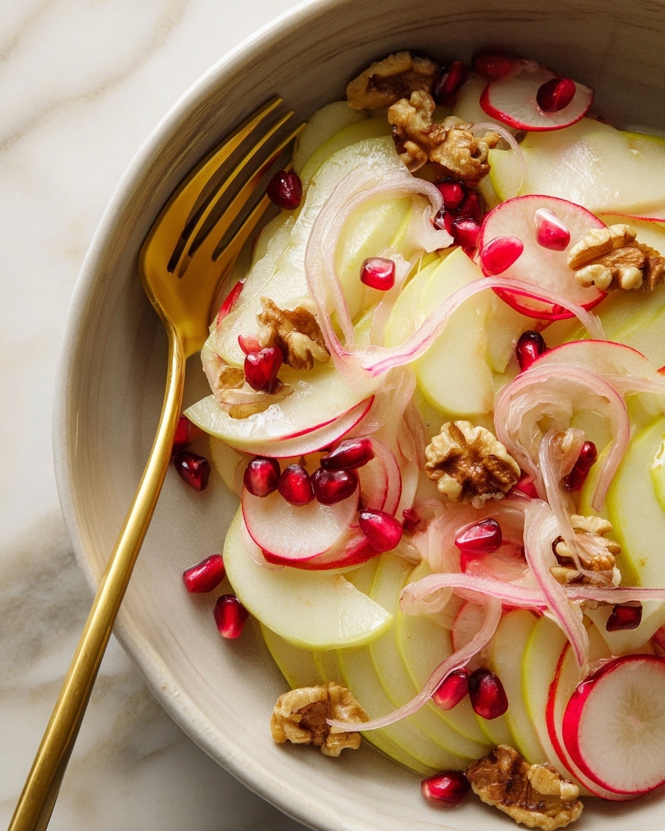 A close-up of a salad in a white bowl showing thin layers of light green apple slices, translucent pale pink onion rings, and thin slices of red radish. These layers are scattered with small pieces of brown walnut and deep red pomegranate seeds. A gold fork is placed inside the bowl holding a few slices of onion and radish, resting over the layers. The bowl is placed on a white marbled surface. Photo taken with an iphone --ar 4:5 --v 7