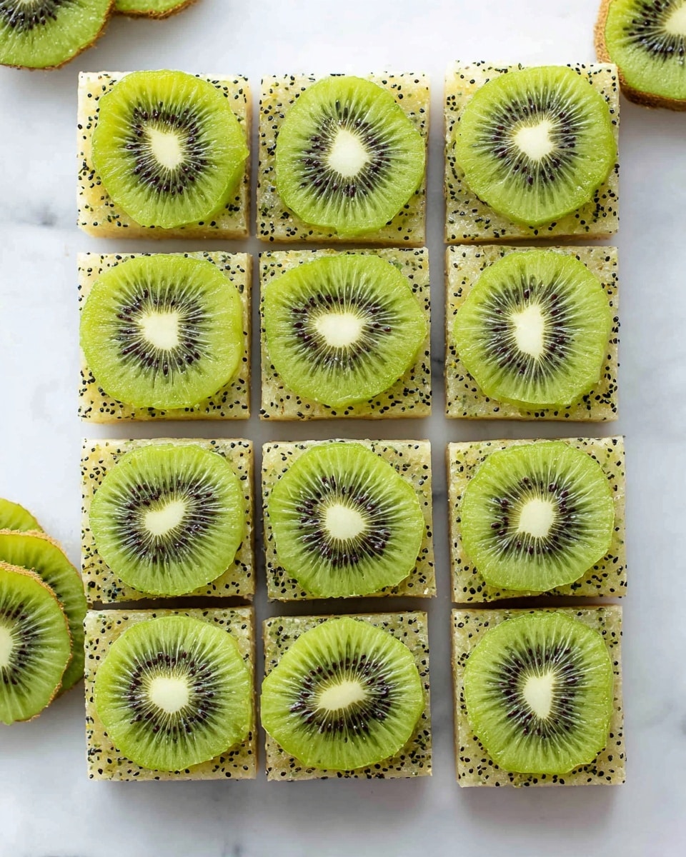 Nine square pieces of a light green, speckled base with visible small black seeds neatly arranged in a 3x3 grid on a white marbled surface. Each square base layer is topped with a single round slice of bright green kiwi, showing its white and black seed pattern in the center, creating a fresh and vibrant contrast. Around the grid, additional whole and sliced kiwi fruits are casually placed for decoration. The overall look is clean, fresh, and colorful. photo taken with an iphone --ar 4:5 --v 7
